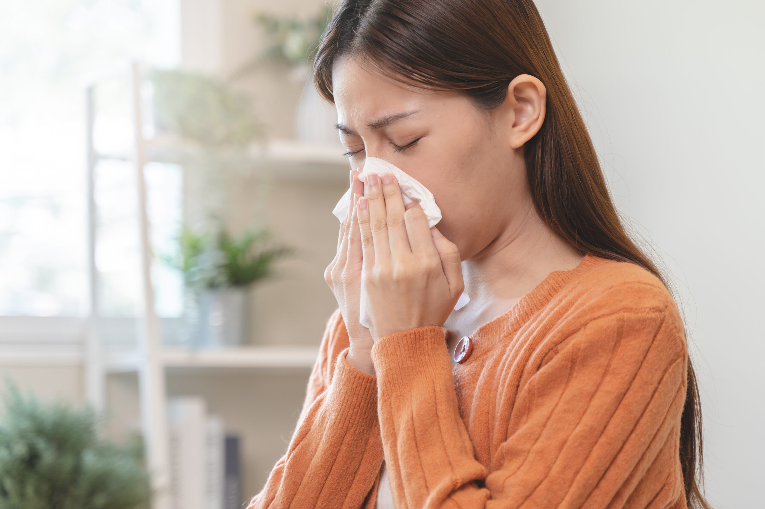 Close-up woman Asian woman sneezing from allergy on tissue paper at home. Close-up woman Asian woman sneezing from allergy on tissue paper at home.
