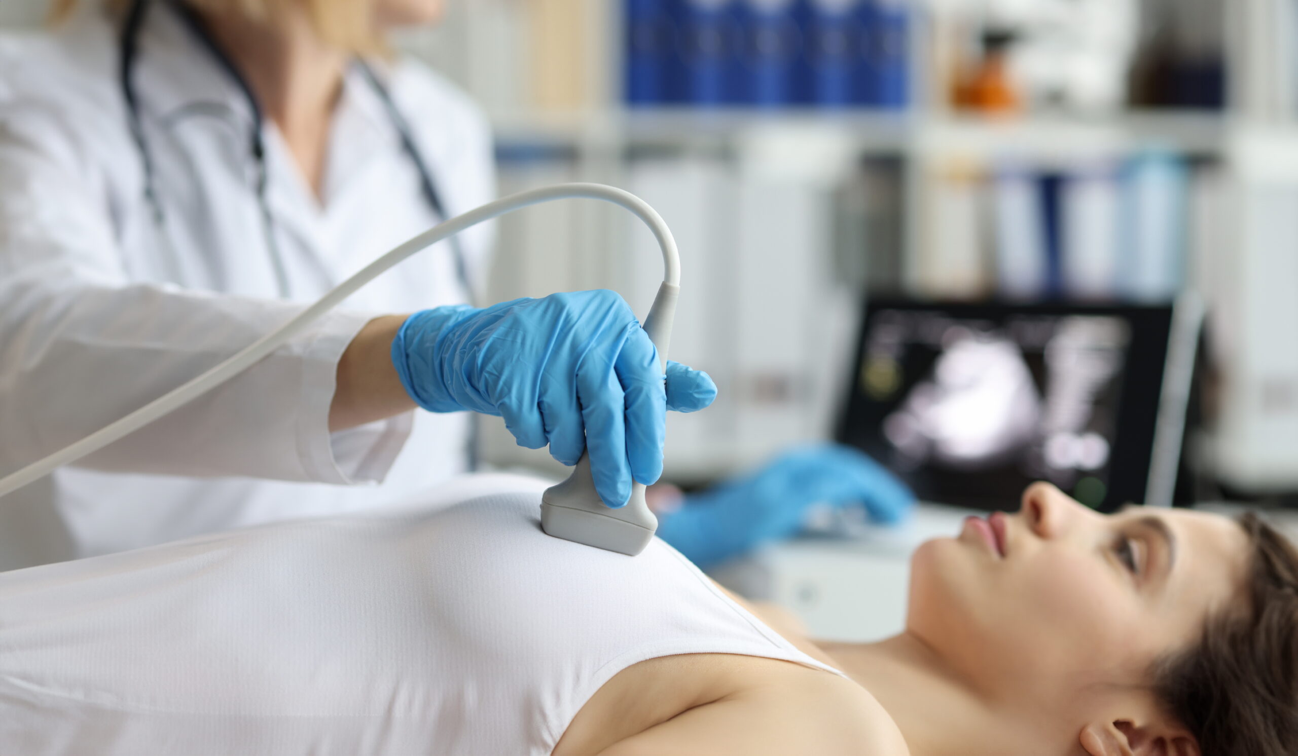 Doctor makes woman breast ultrasound, treatment before breast augmentation, full checkup in clinic Portrait of doctor makes woman breast ultrasound, treatment before breast augmentation, full checkup in clinic. Womans health, medicine, hospital concept